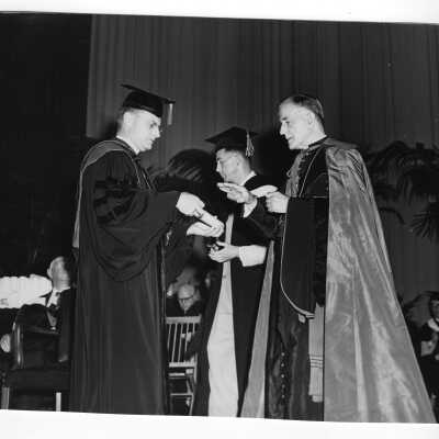 Edward G. Jacklin, S.J., bestowing honorary degree on Bishop Daniel Gercke at 1953 graduation/commencement ceremony.