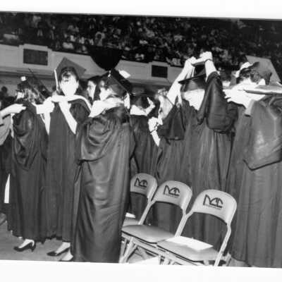 Graduating students donning hoods during 1990 graduation/commencement.