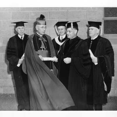 Edward G. Jacklin, S.J. with honorary degree recipients, Bishop John F. O'Hara, Francis J. Hardart, and Joseph Breen, and Bartholomew A. Sheehan, speaker, at 1954 graduation/commencement ceremony.