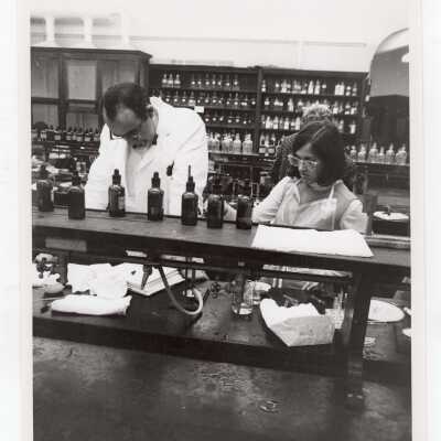 Chemistry professor working in science laboratory with two students, c. 1968.