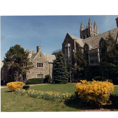 Exterior view of front of Barbelin in spring with daffodils and forsythia blooming.