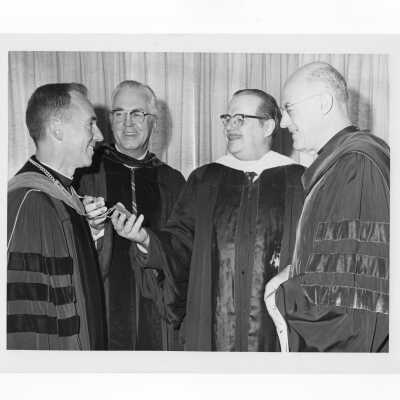Inauguration of President Terrence Toland, S.J., November 14, 1968. Before ceremony, Toland shows Chain of Office to U.S. Senator Hugh Scott of Pennsylvania, with Mayor James Tate and Paul Reinert, S.J. looking on.