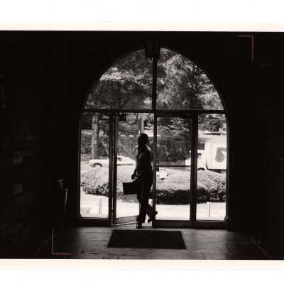 Interior view of man entering Barbelin through glass doors of central archway off City Avenue.