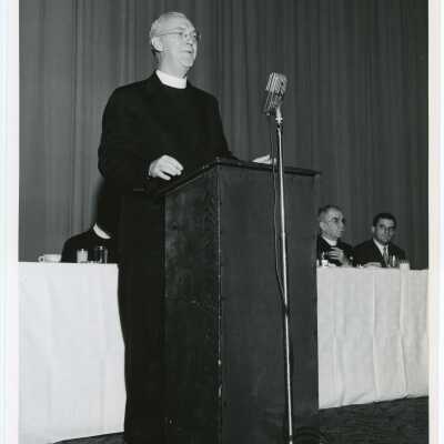 J. Joseph Bluett, S.J. (President) speaking during dinner, October 1956.