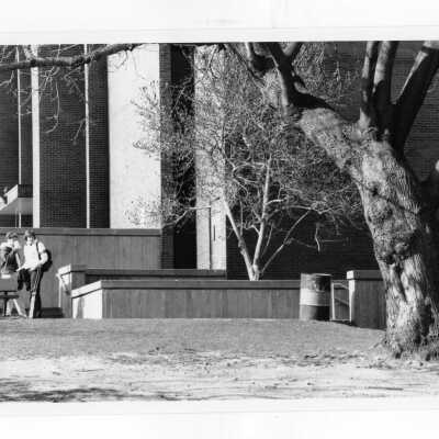Two students standing and talking outside of science center.