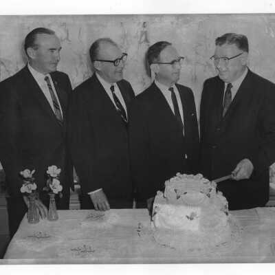 Four men cutting cake at twenty-fifth anniversary of campus restaurant, c. 1965. (Horn & Hardart Restaurant at corner of 54th Street and City Line Avenue).