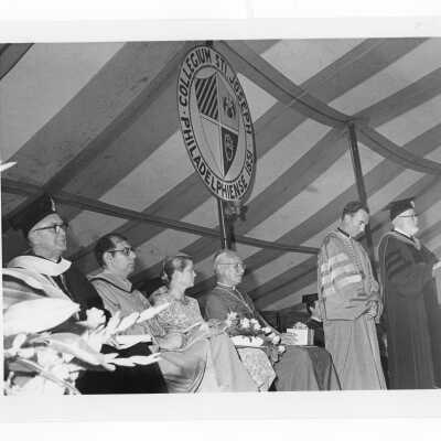 Dr. James Dougherty reading citation of honorary degree to outgoing SJC president, Terrence Toland, S.J., during academic convocation held on Gest Lawn, July 31, 1976, as part of SJC 125th anniversary celebration.