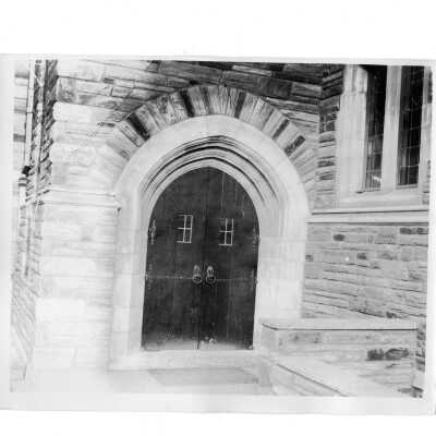 Exterior view of wooden doors in one of archway entrances.