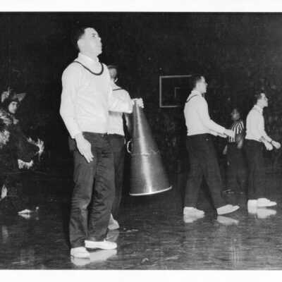 Men's Basketball, cheerleaders with megaphone and Hawk Mascot at game.