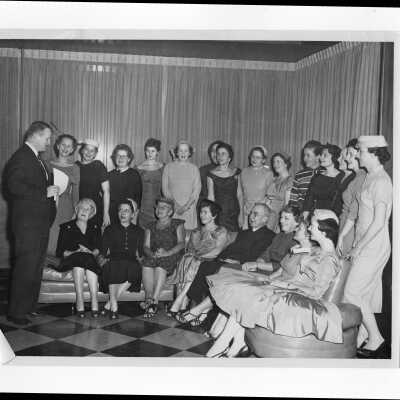 James Mundy and Joseph S. Hogan, S.J., with wives of alumni association members planning a supper dance, c. 1960.