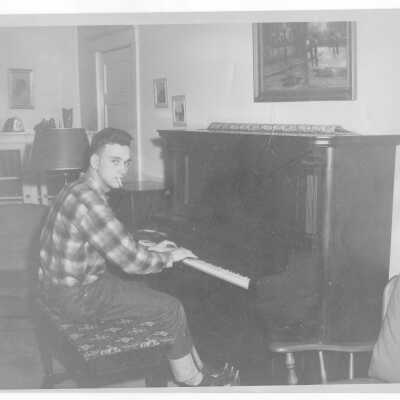 Student resident from Barry Hall playing piano and smoking a cigarette.