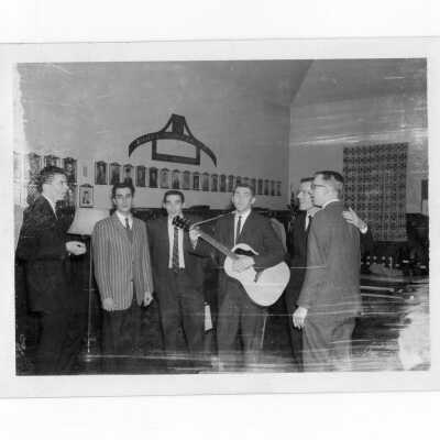 Students in Quirk Hall residence singing as one of them plays a guitar. There are two different photos, taken at different times, in different parts of the house. These photos were collected by Francis Emory, S.J. in addition to another much larger set