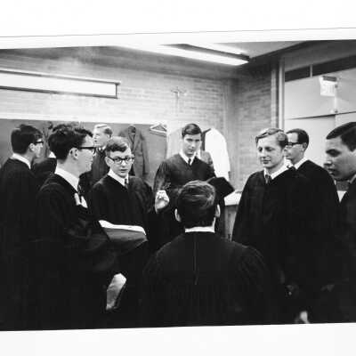 Graduates putting on robes in Bellarmine classroom during 1968 graduation/commencement.
