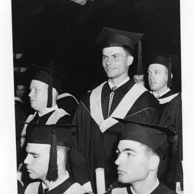View of several graduating students during 1954 graduation/commencement ceremony.