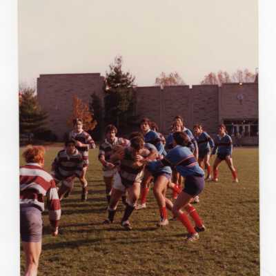 Men's rugby match on Finnesey Field with Post Hall (formerly Villiger) in background.
