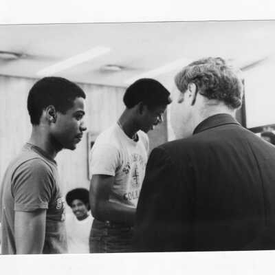 Joseph J. Feeney, S.J.: Faculty, English. One shows class outdoors, and one shows meeting of African American Students.