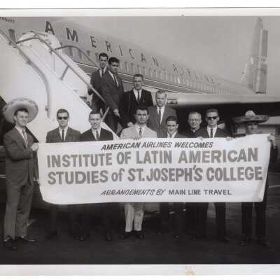SJC students in Latin American Studies program boarding airplane for Mexico City to participate in internship program, July 1964. Includes Matthew Sullivan, S.J., J. Pachioli, D. KiIenno, E. Koschineg, F. Arnold, T. Yeager, F. Kelly, J. Morris, J. Tozzi