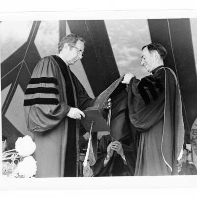 Terrence Toland, S.J., conferring honorary degree on F. Otto Haas (honorary consul general, Federal Republic of Germany) during 1976 graduation/commencement.
