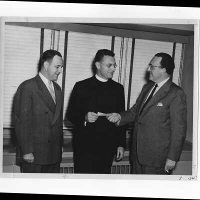 Edward G. Jacklin, S.J., receiving check from alumni officers, Robert G. Cranage and William Berry, Sepetember 23, 1952.