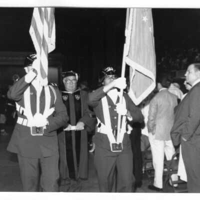 Color guard leading Nicholas S. Rashford, S.J., and others in recessional during 1990 graduation/commencement.