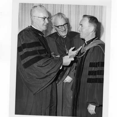 Inauguration of President Terrence Toland, S.J., November 14, 1968. Before ceremony, Toland shows Chain of Office to the Mayor of Philadelphia, James H.J. Tate and another man during picture-taking session.