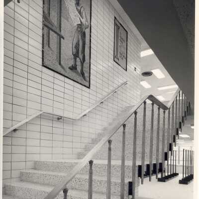 Interior view of mosaic art pieces on wall of main steps in Drexel Library. The mosaics depict Gutenberg and the printing press and Latin for "In the beginning was the word and the word was God."