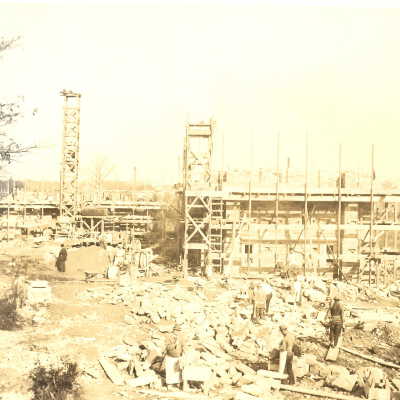 Early construction of Barbelin building with several workmen.