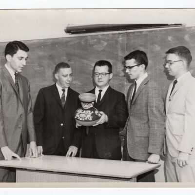 Dr. Robert T. Quigley and students--M. Kushnerock, C. Purkenage, R. Potts, and J. Porcelli-- look at piece of decorative pottery during Pan American Observance, c. 1968.