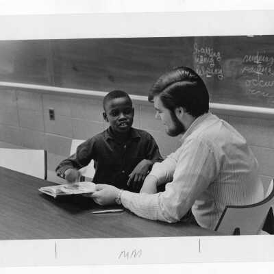 Student tutoring child at Rhoads Public School (?) as part of community service/outreach project. (Peace and Human Development program?)