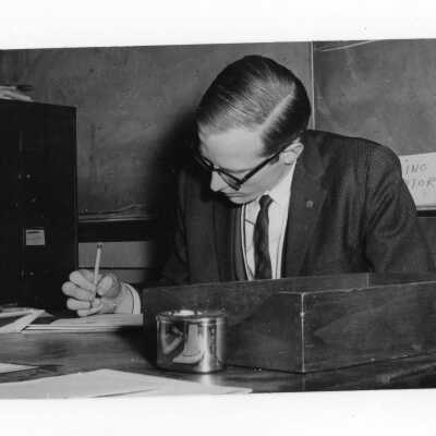 Student editor of The Hawk newspaper working at desk.