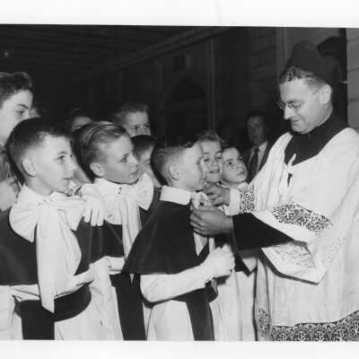 Altar boys with Edward G. Jacklin, S.J. during pontifical mass for centennial celebration held in Field House.