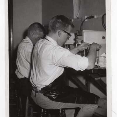 Two chemistry students working on experiment in science laboratory, c. 1965.