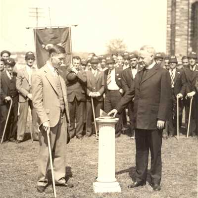 William T. Tallon, S.J. at sundial with student, Edward C. Trainer, and other students with caps and canes during Junior Week ceremony.