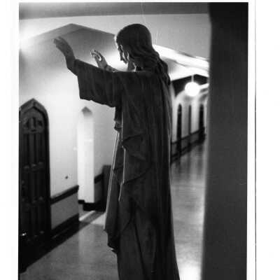 Interior view of hallway in Barbelin with statue of Jesus.