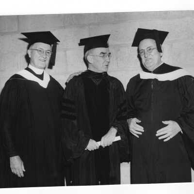 Joseph S. Hogan, S.J. with two alumni from class of 1900 receiving golden hawk awards as part of 1950 graduation/commencement ceremony. Alumni include Reverend Daniel Lawless and John McCusker.