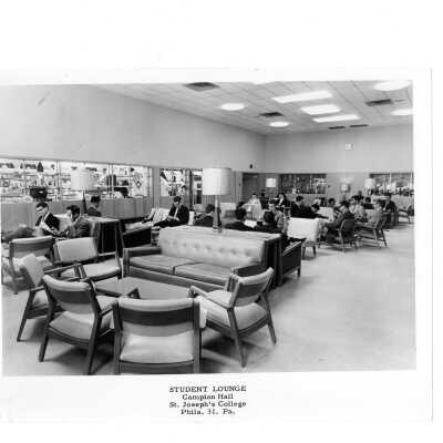 Students in sitting in Campion lounge with bookstore in background.