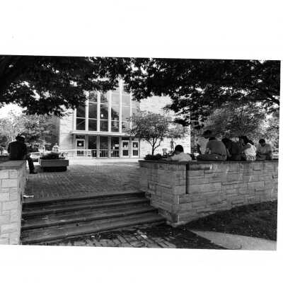 Exterior view of side of Villiger (later Post) Academy of Food Marketing with students sitting on walls.