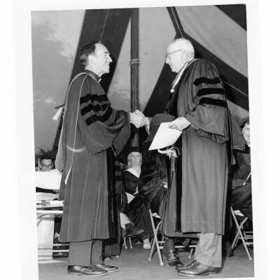 Terrence Toland, S.J., congratulating faculty honoree (?) during 1976 graduation/commencement.