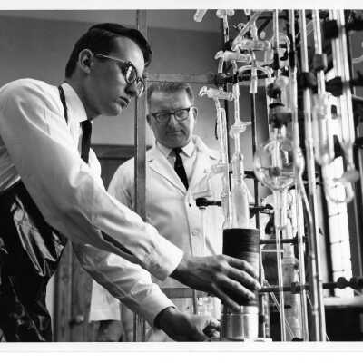 George J. Beichl (Chemistry) observing student conducting experiment in science laboratory in Barbelin.