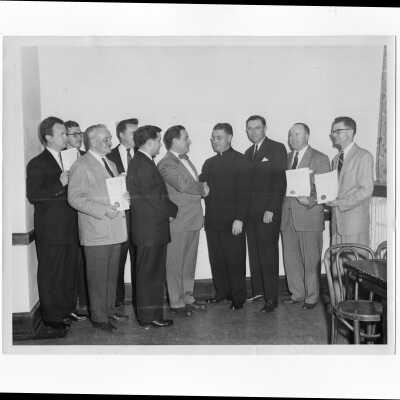 Edward G. Jacklin, S.J., congratulating alumni group including Francis Lammer and Paul E. Kelly (?), c. 1953.