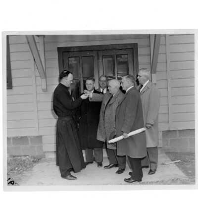 Dedication of Cardboard College (also known as Barbelin Annex) located near veterans barracks with James Buckley, S.J. (?), Emile G. Perrot, and members of Federal Works Agency.