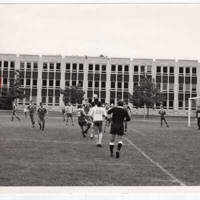 Men's soccer match on Finnesey Field with Post Hall (formerly Villiger) in background.