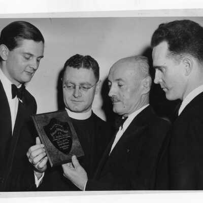 Student from Villiger Debating Society presenting trophy for international debate with Oxford to Edward G. Jacklin, S.J.