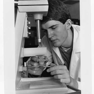 Male student in science laboratory conducting an experiment.