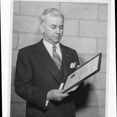 Dr. Francis Braceland holding Shaffrey award, April 8, 1956.