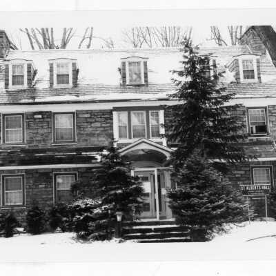 View of front of Saint Albert's Hall in the snow.