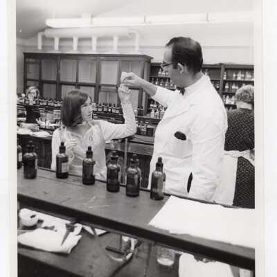 Chemistry professor working in science laboratory with several students, c. 1968.