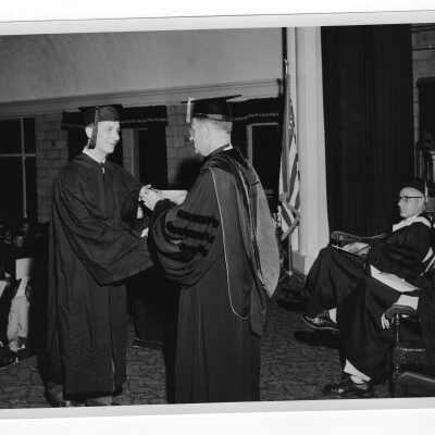 Tropaia exercises during 1955 graduation/commencement with Edward G. Jacklin, S.J. and student.