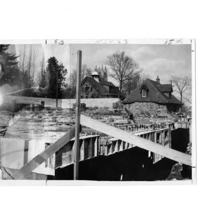 Framing for Campion building with view of carriage house and Simpson Hall [?] in background.