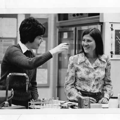 Two women students conducting experiment in science laboratory.